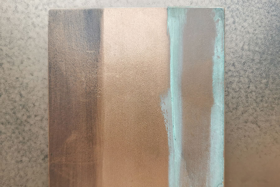 Musterplatte mit verschiedenen, bronzefarbenen Metalloberflächen