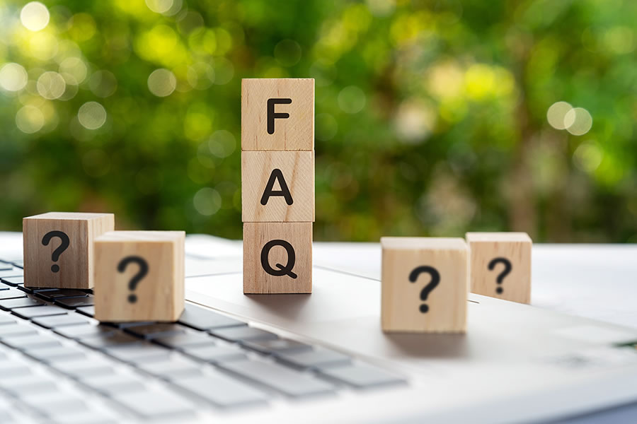 Holzwürfel mit Fragezeichen und FAQ-Buchstaben